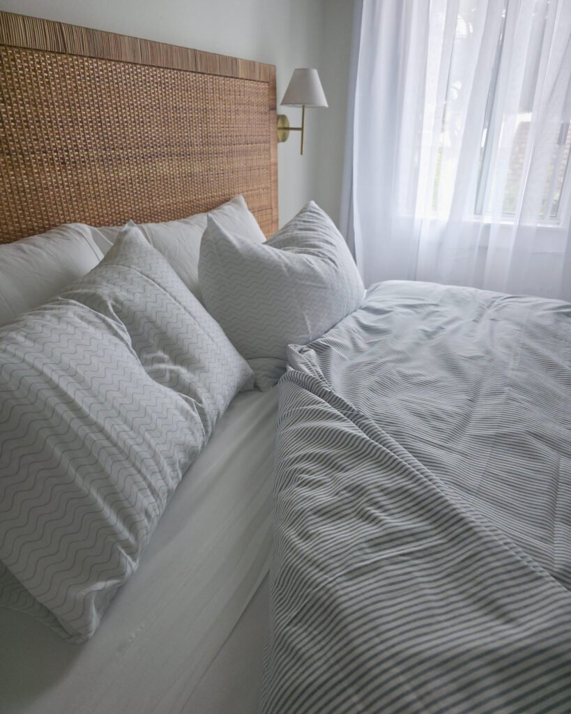Denim cover, pillowcases white with thin blue wave, angled (lifestyle)